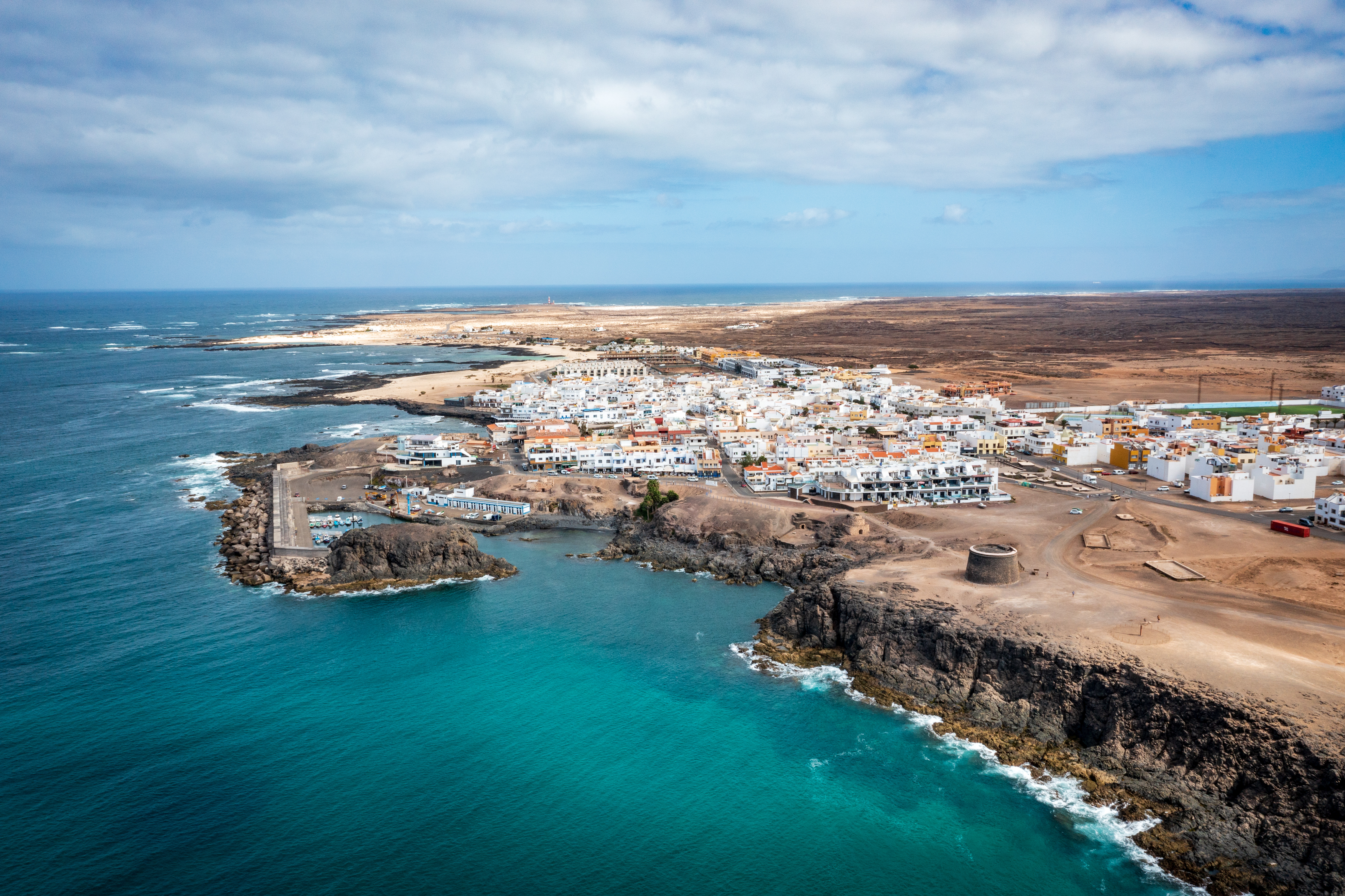 Aerial photograph of the coastline near El Cotillo showing the historic Castillo de El Tostón watchtower on the headland